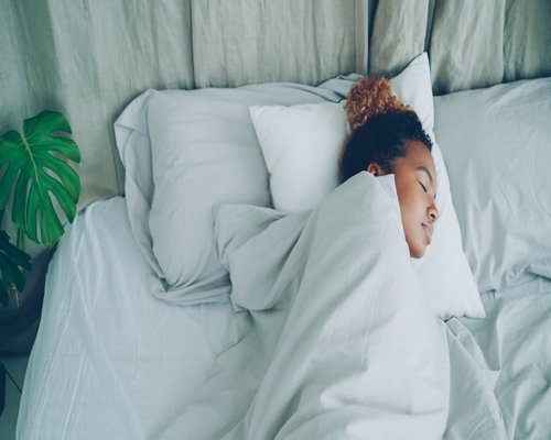 Person sleeping peacefully in a comfortable bed